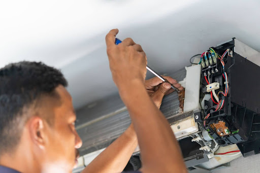 G.F. Bowman technician fixing indoor air conditioner.